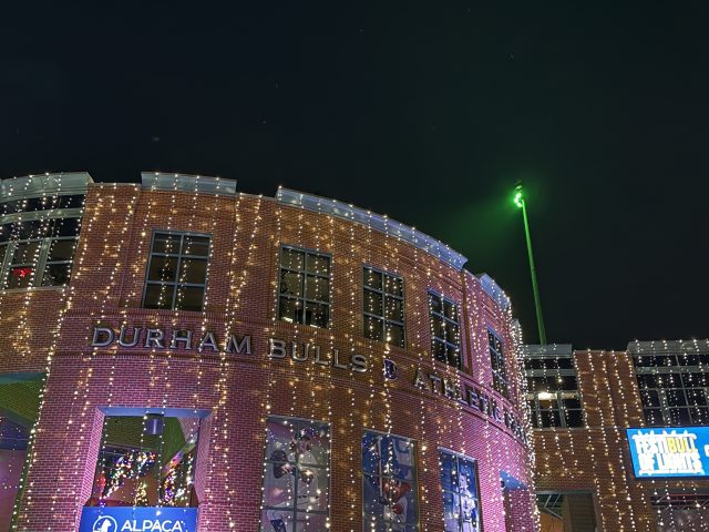 Front of Durham Bulls stadium in Christmas lights with green stadium light for NIPD